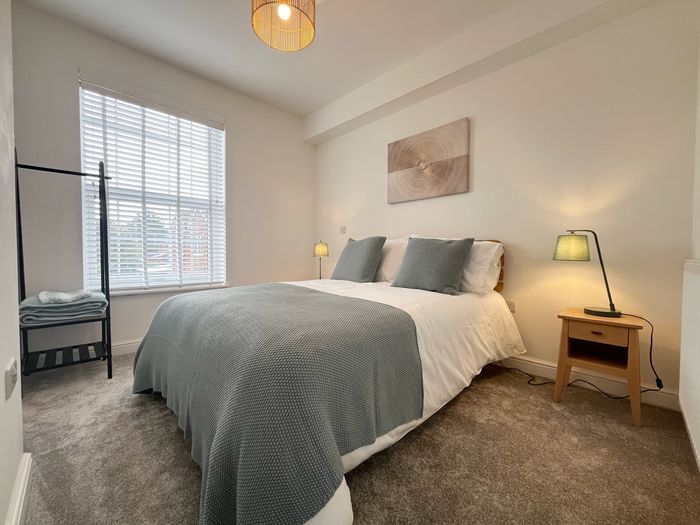 Second bedroom with a double bed, folded towels and a clothes rail by the window