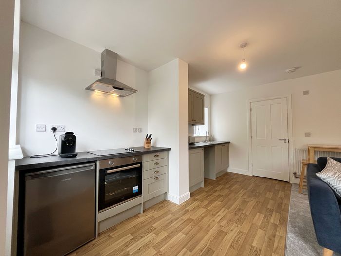 Kitchen with oven, induction hob, fridge and coffee machine, open to the living area