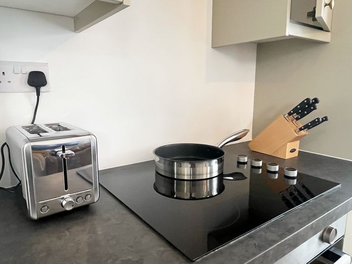 Induction hob with a stainless steel pan, toaster and knife block