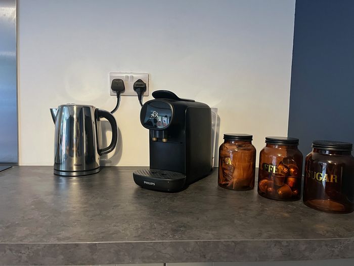 Kettle, coffee machine and amber tea, coffee and sugar jars on the worktop