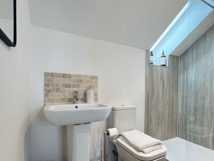 Shower room with a walk-in shower, basin and heated towels